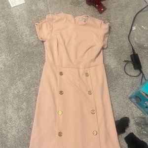 Pink dress with gold buttons down the dress.